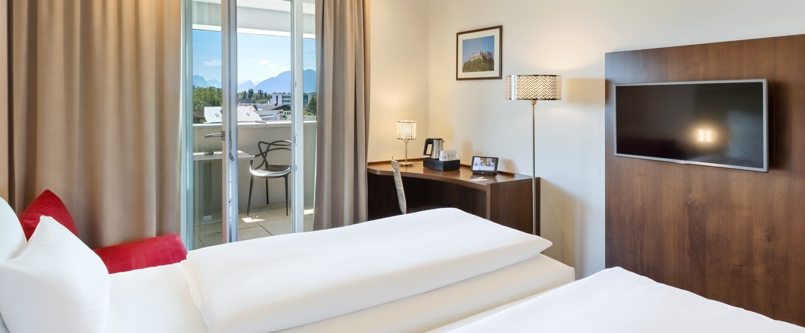 Innenansicht Superior Zimmer mit Blick auf Bett und Balkon| Hotel Salzburg Messe